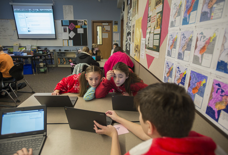 Seventh-grader Jordan Peterson, 12, from left, joins classmates Anna McCready, 12, and Paige Barrett, 13, as they use their Dell Chromebooks to work on a project at Chief Umtuch Middle School in Battle Ground on Thursday morning. The district is putting a levy before voters on Feb. 14. Part of the funding supports technology in classrooms.