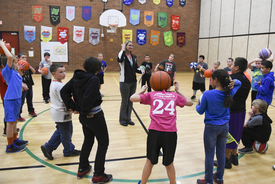 Parent volunteer Julie Perry, center, directs Burnt Bridge Creek Elementary School students in their basketball club on Dec. 1 during an after-school program. The east Vancouver school in the Evergreen Public Schools district has phased out traditional homework and replaced it with after-school clubs.
