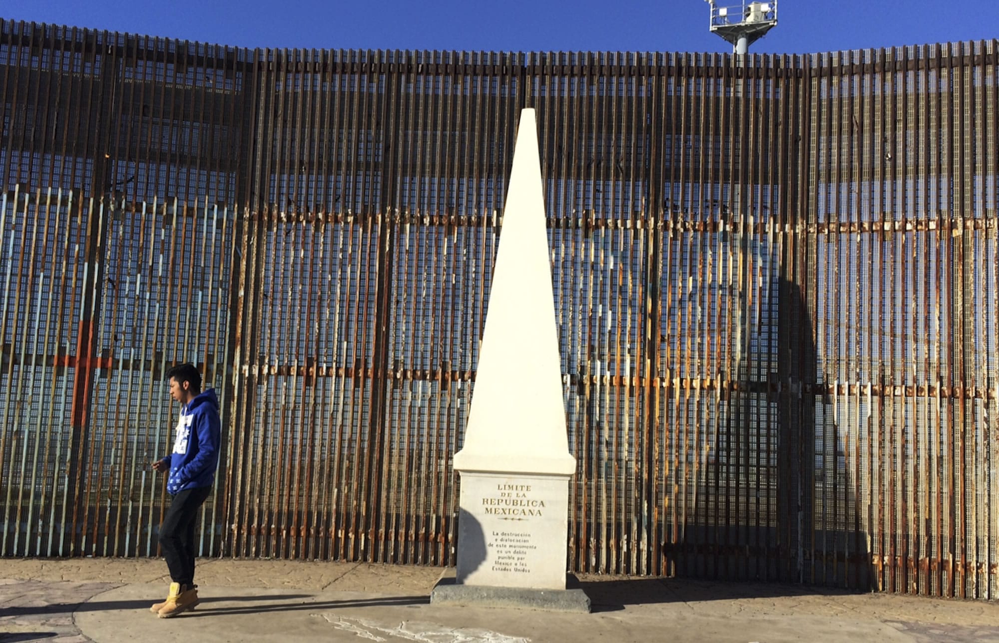CORRECTS FROM AZUL TO DZUL- Brandon Dzul, 17, walks away from a monument marking Mexico's border with the United States in Tijuana, Mexico, Wednesday, Jan. 25, 2017.