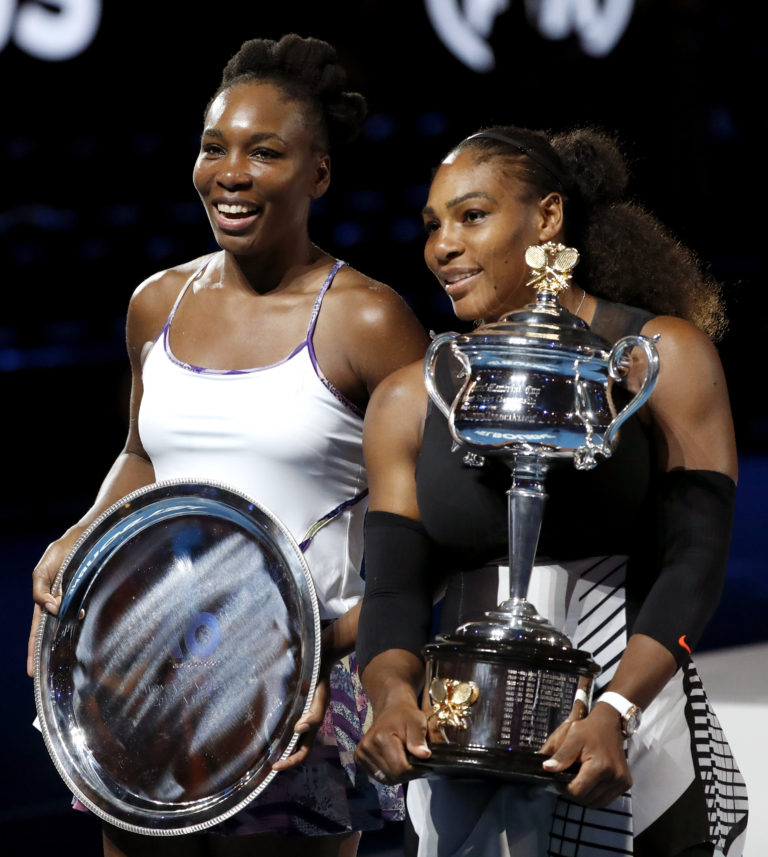 United States' Serena Williams, right, and her sister Venus hold their trophies after Serena won their women's singles final at the Australian Open tennis championships in Melbourne, Australia, Saturday, Jan. 28, 2017.