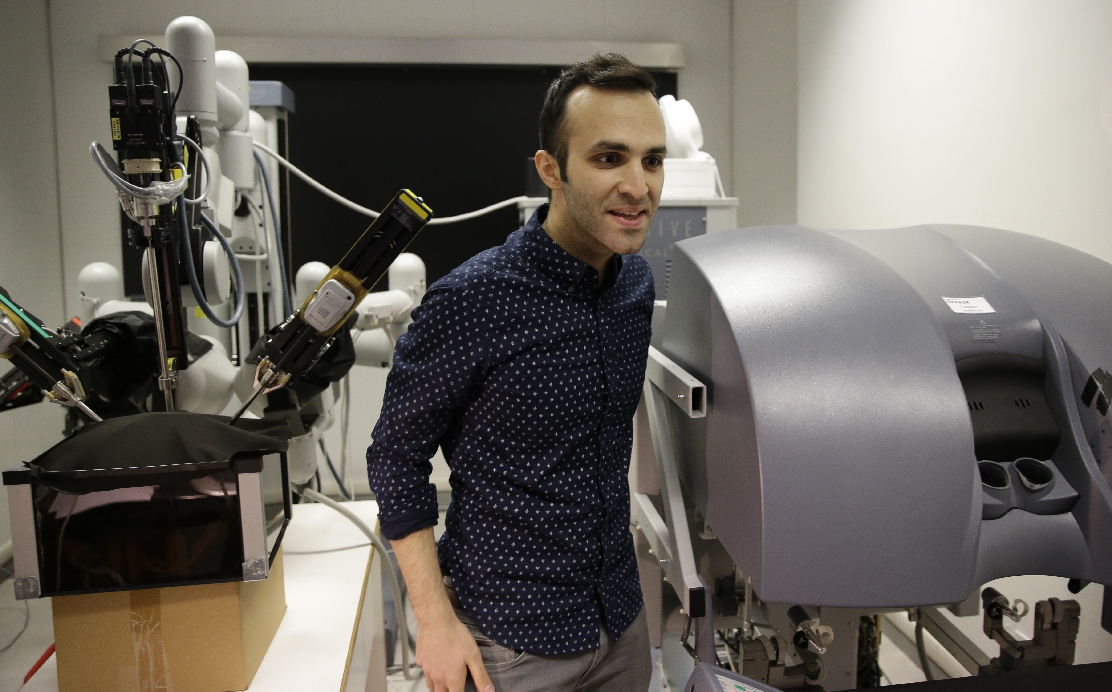Iranian-born bioengineer researcher Nima Enayati stands as he works on a robotic surgery machine during an interview with the Associated Press at the Polytechnic University of Milan, Italy, Tuesday, Jan. 31, 2017. An Iranian researcher at Milan's Polytechnic University, Enayati was refused check-in Monday at Milan's Malpensa Airport for his U.S.-bound flight on Turkish Airlines after the Trump administration's executive order came down.