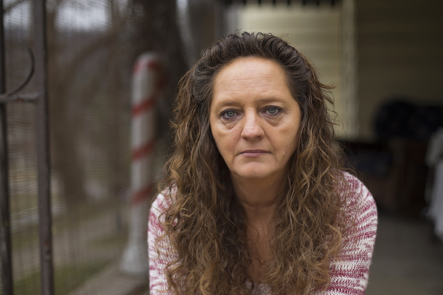In this Monday, Dec. 19, 2016, photo, Donna Dye, who is unemployed and whose husband is disabled, sits outside her home in Minnie, Ky. She and her husband have been fighting the federal government to keep his Social Security disability checks after a local lawyer who helped them became the subject of a federal fraud investigation.