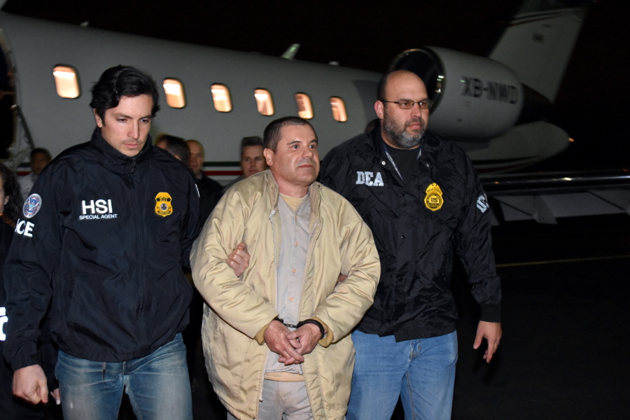 Authorities escort Joaquin &quot;El Chapo&quot; Guzman, center, from a plane to a waiting caravan of SUVs at Long Island MacArthur Airport on Thursday in Ronkonkoma, N.Y. The infamous drug kingpin who twice escaped from maximum-security prisons in Mexico was extradited at the request of the U.S. to face drug trafficking and other charges, and landed in New York late Thursday, a federal law enforcement official said. (U.S.
