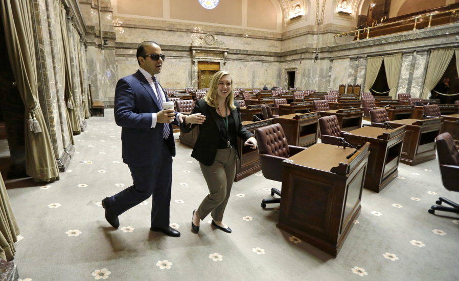 Washington Lt. Gov.-elect Cyrus Habib, left, carries coffee as he walks with his staff member Libby Hollingshead,  Director of Operations and Legislative Liaison,  in the Senate chamber, Thursday, Jan. 5, 2017, in Olympia, Wash. Habib will be Washington&#039;s first blind lieutenant governor, and the Senate has undergone a makeover that incorporates Braille into that chamber&#039;s floor sessions that will allow Habib to know by the touch of his finger which lawmaker is seeking to be recognized to speak. Habib is replacing Lt. Gov. Brad Owen, who is retiring. (AP Photo/) (Photos by Ted S.