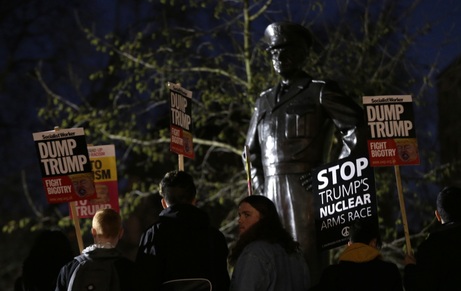 Campaigners demonstrate outside the United States Embassy in front of a statue of former US President and World War II general Dwight Eisenhower as they protest about the inauguration of U.S President Donal Trump, in London, Friday, Jan. 20, 2017.