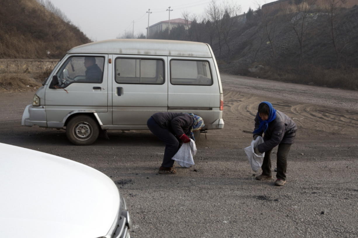 A villager surnamed Shen, left and another fellow villager pick up pieces of coal that fell from overfilled coal trucks tumbling down an uneven junction near the Shougang steel factory in Qianan in northern China&#039;s Hebei province. Across vast swathes of northern China, particularly in the poor countryside, residents still go to great lengths to acquire and burn coal for warmth despite government efforts to ban the practice and introduce cleaner, but costlier, types of coal or electrical heating.
