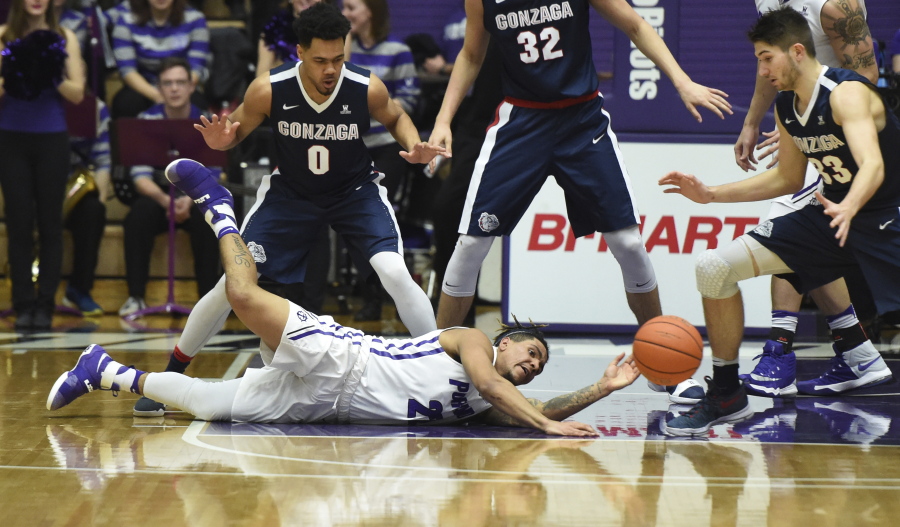 Portland guard Jazz Johnson dives on the floor the ball as Gonzaga guard Silas Melson and forward Killian Tillie look on during the first half of an NCAA college basketball game in Portland, Ore., Monday, Jan. 23, 2017.