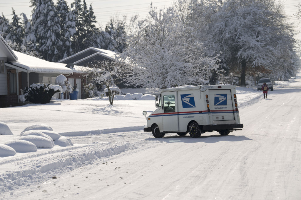 A mailman navigates snowy streets in Northwest Vancouver near Franklin Park on Friday.