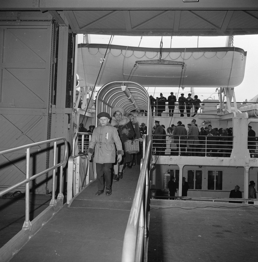 Passengers disembark from the Polish ship M.S. Batory, the first immigrant ship to dock in Boston in 20 years, as others wait for clearance on the deck Dec. 29, 1965. Some 450 immigrants from Iron Curtain countries and 200 tourists were aboard the vessel when it docked Dec. 29, 1965. Most of the immigrants are bound for Detroit and Chicago. Immigration to the U.S. has come in swells and dips over the past two-plus centuries, driven by shifts in U.S. policy, the mood in the country and world events. Labor shortages, racial tension, economic forces, religious prejudice and national security concerns all fit into the picture.
