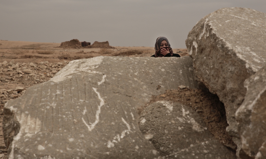 Iraqi archaeologist Layla Salih examines the remains of a statue of a lamassu, a mythical winged bull, destroyed by Islamic State group militants in the ancient site of Nimrud, Iraq,on Dec. 14. Salih is perhaps the only vigilant guardian left for the ruins: Since the militants were driven out more than a month ago, she has visited multiple times, trying to prevent looting of the wreckage.