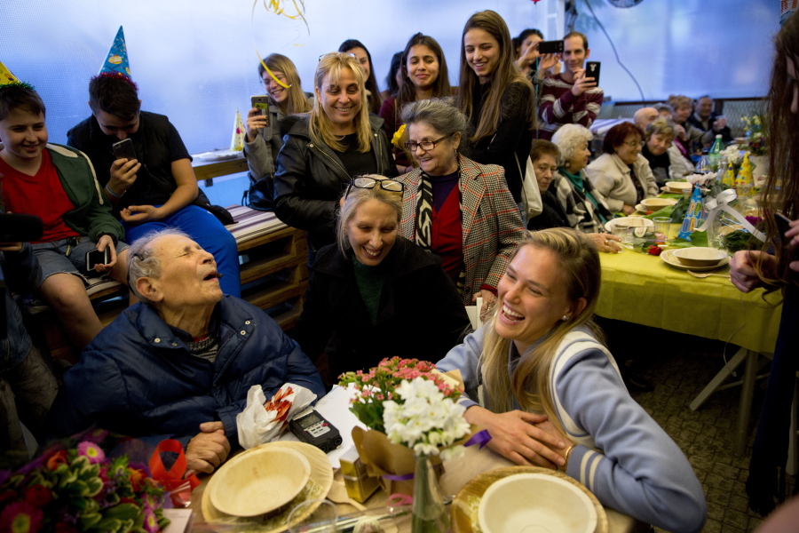 Israeli Holocaust survivor Ernest Weiner shares a table Wednesday with Israeli supermodel Bar Refaeli during his 92nd birthday party in a restaurant in the central Israeli city of Ramat Hasharon. More than 100 fellow Holocaust survivors and advocates on their behalf gathered for the party. Weiner, a blind widower who uses a wheelchair to get around, still lives on his own. &quot;It is not pleasant to be alone,&quot; he said.