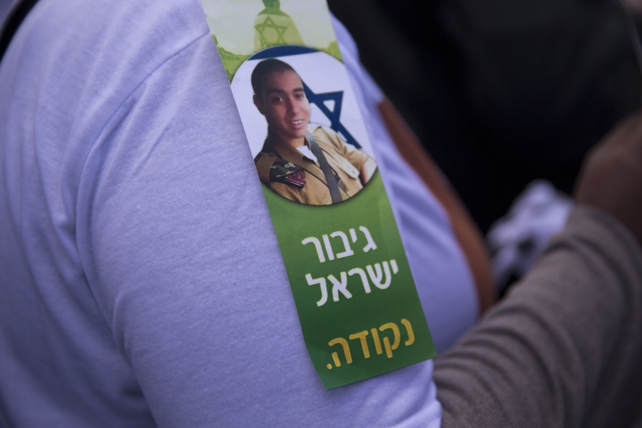 An Israeli hardline nationalist supporter of Israeli army medic Sgt. Elor Azaria wears a sticker with hi photo and Hebrew which reads, &quot;Israel Hero Period,&quot; as she protests outside the Israeli military court in Tel Aviv, Israel, on Wednesday. Scuffles erupted outside the courtroom between supporters of Azaria, who was convicted of manslaughter in the deadly shooting of an incapacitated Palestinian attacker, and police officers. The verdict, which marks an extremely rare case of an Israeli military court siding against a soldier over lethal action taken in the field.