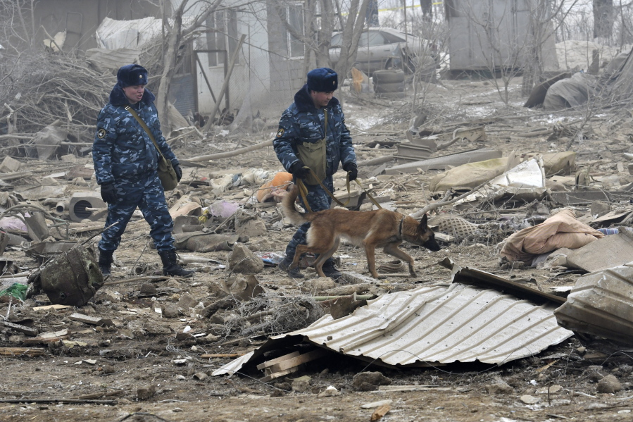 Kyrgyz soldiers with a sniffer dog search among remains of a crashed Turkish Boeing 747 cargo plane at a residential area outside Bishkek, Kyrgyzstan, on Monday. The cargo plane crashed Monday morning, killing people in the residential area adjacent to the Manas airport as well as those on the plane.