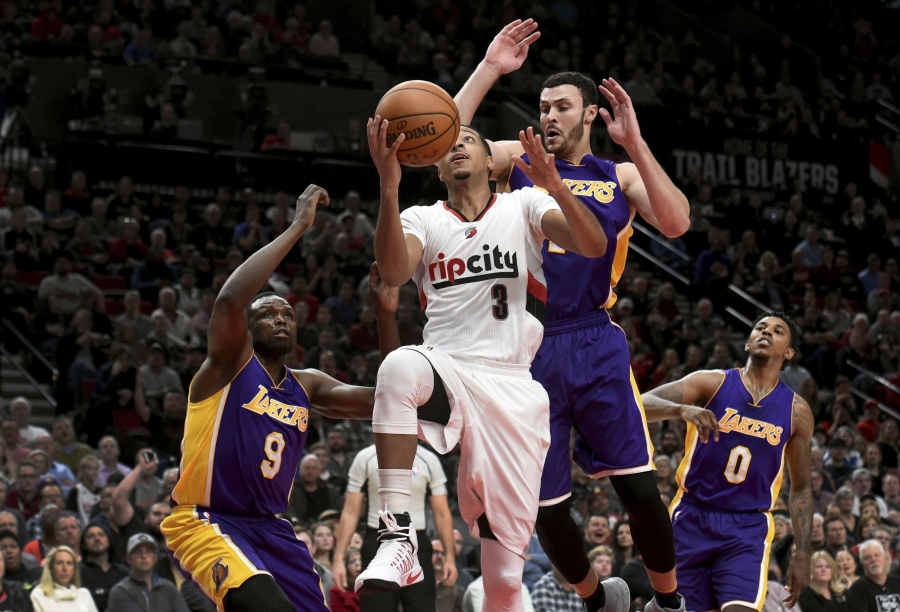 Portland Trail Blazers guard C.J. McCollum drives to the basket and scores on Los Angeles Lakers&#039; Luol Deng, Larry Nance Jr. and Nick Young during the second half of an NBA Portland basketball game in Portland, Ore., Wednesday, Jan. 25, 2017. The Blazers won 105-98.