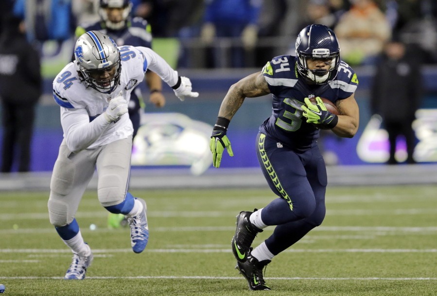 Seattle Seahawks running back Thomas Rawls, right, rushes as he is pursued by Detroit Lions defensive end Ezekiel Ansah (94) in the first half of an NFL football NFC wild card playoff game, Saturday, Jan. 7, 2017, in Seattle.