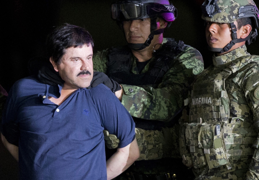 A handcuffed Joaquin &quot;El Chapo&quot; Guzman is made to face the press Jan. 8 as he is escorted to a helicopter by Mexican soldiers and marines at a federal hangar in Mexico City. The cartel kingpin was extradited to the United States on Thursday to face drug trafficking charges.