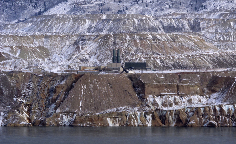 Tthe Horseshoe Bend Treatment Plant is seen at the far shore of the Berkeley Pit in Butte, Mont. Federal officials plan to pump the toxic water into the plant starting in 2023 to keep it below a critical level and prevent it from escaping the pit.