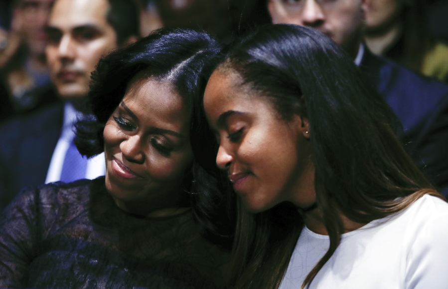 First lady Michelle Obama and daughter Malia lean into one another as they listen to President Barack Obama speak during his farewell address at McCormick Place in Chicago, Tuesday, Jan. 10, 2017.