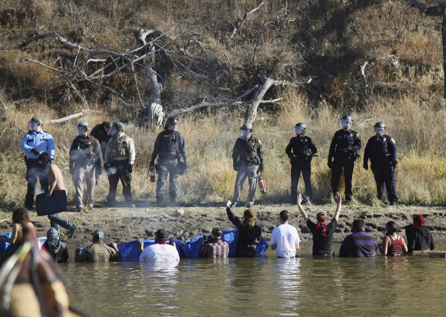 Protesters demonstrating against the Dakota Access Pipeline wade into a creek to confront police Nov. 2 near Cannon Ball, N.D.