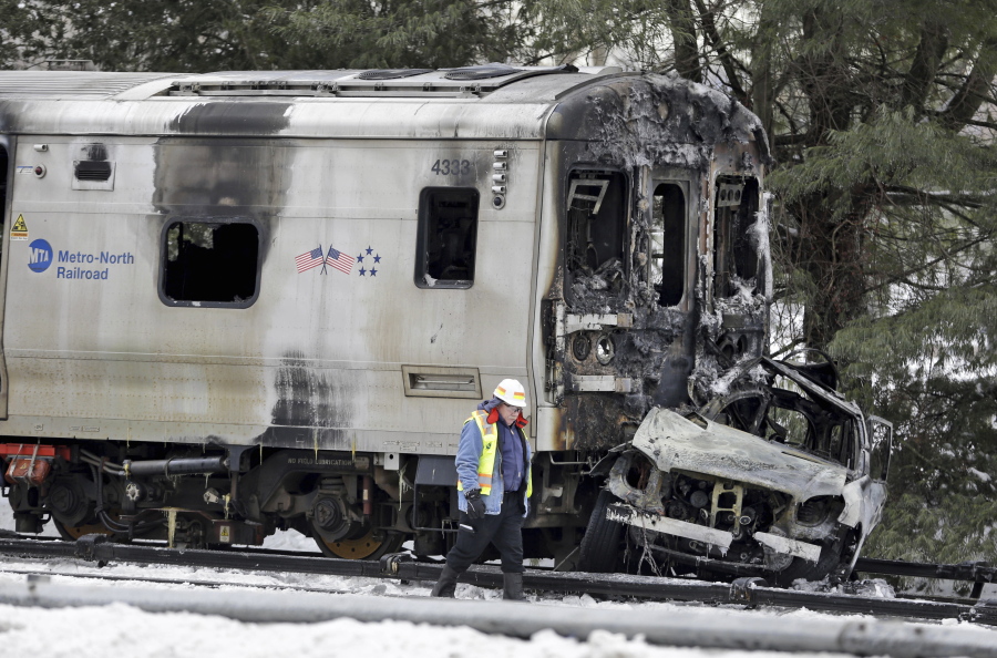 A man wearing a Federal Railroad Administration vest looks over wreckage of a Metro-North Railroad train and an SUV on Feb. 4, 2015, following a collision that killed five train passengers and the SUV&#039;s driver about 20 miles north of New York City in Valhalla, N.Y.