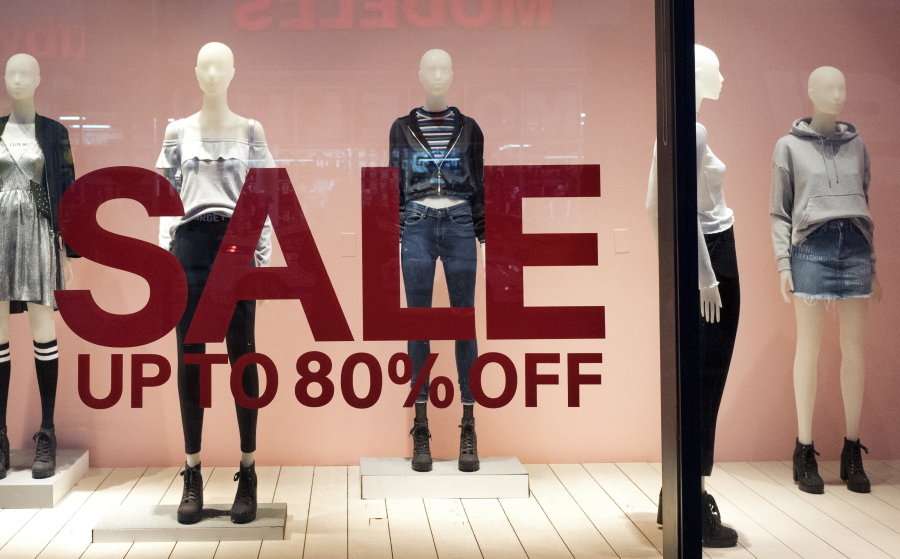 An H&amp;M store window advertises a sale in New York.