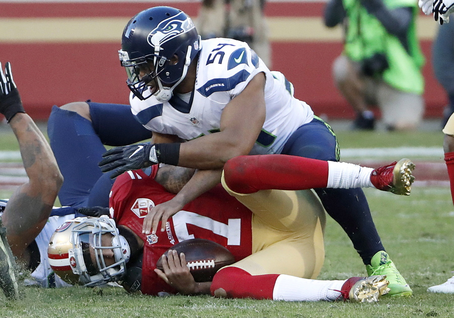San Francisco 49ers quarterback Colin Kaepernick (7) is sacked by Seattle Seahawks middle linebacker Bobby Wagner (54) during the second half of an NFL football game in Santa Clara, Calif., Sunday, Jan. 1, 2017.