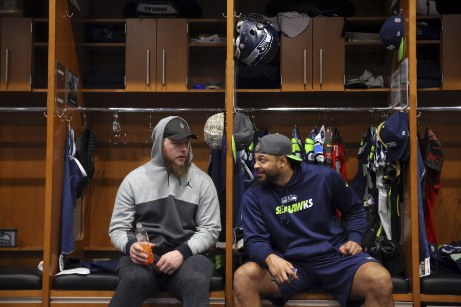 Seattle Seahawks offensive linemen Justin Britt, left, and Garry Gilliam talk as players clean out their lockers in Renton on Sunday.