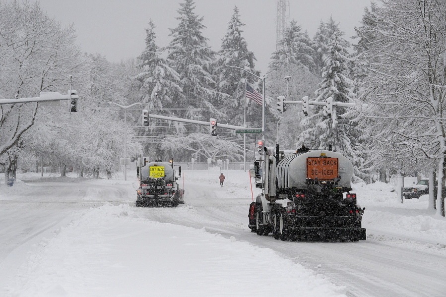 Snow plows clear the street along Fort Vancouver Way on Wednesday morning, Jan. 11.