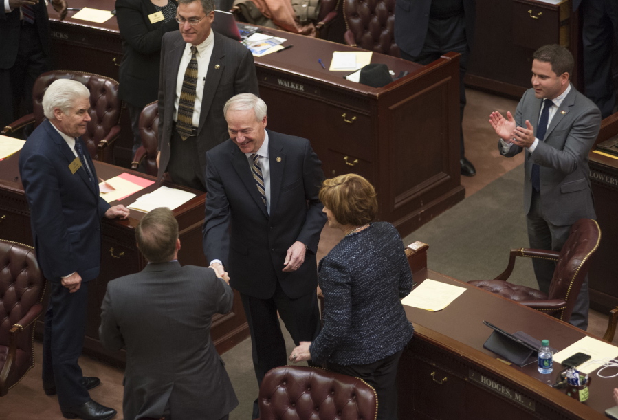 Arkansas Gov. Asa Hutchinson, center, greets legislators before his address to a joint session 91st General Assembly at the state Capitol in Little Rock, Ark.