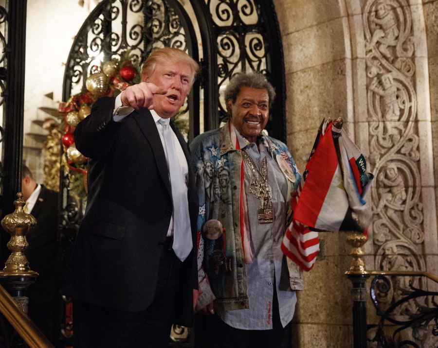 President-elect Donald Trump, left, stands with boxing promoter Don King as he speaks to reporters at Mar-a-Lago, in Palm Beach, Fla.