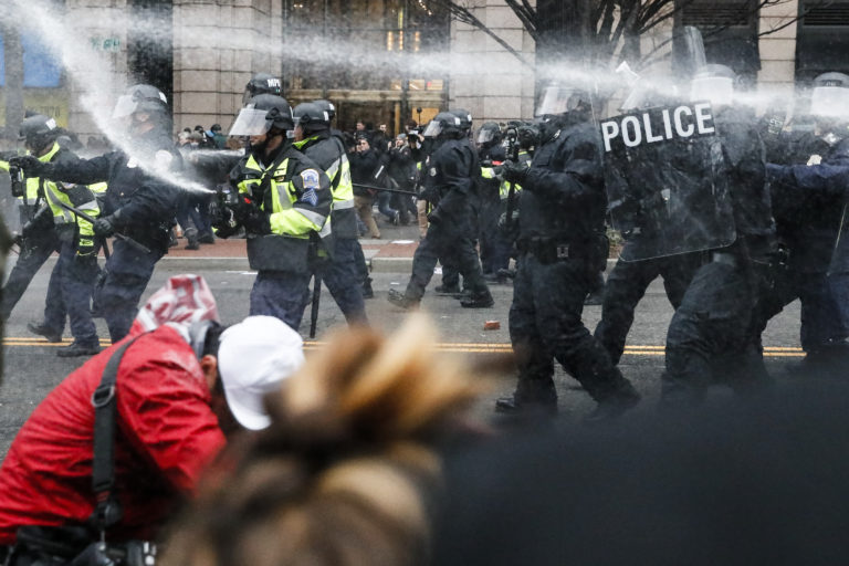 Police fire pepper spray at protestors during a demonstration in downtown Washington, Friday, Jan. 20,2017, after the inauguration of President Donald Trump.