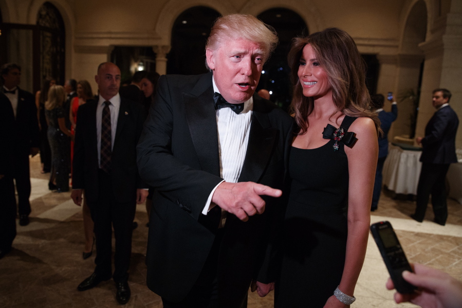 Melania Trump, right, looks on as her husband President-elect Donald Trump talks to reporters during a New Year&#039;s Eve party at Mar-a-Lago, Saturday, Dec. 31, 2016, in Palm Beach, Fla.