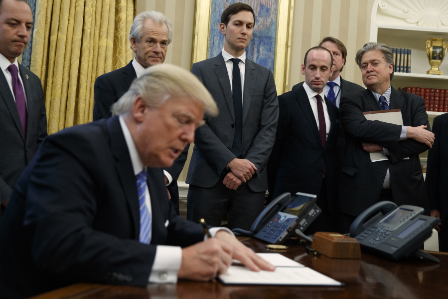 From left, White House Chief of Staff Reince Priebus, National Trade Council adviser Peter Navarro, Senior Adviser Jared Kushner, policy adviser Stephen Miller, and chief strategist Steve Bannon watch as President Donald Trump signs an executive order in the Oval Office of the White House on Monday in Washington.