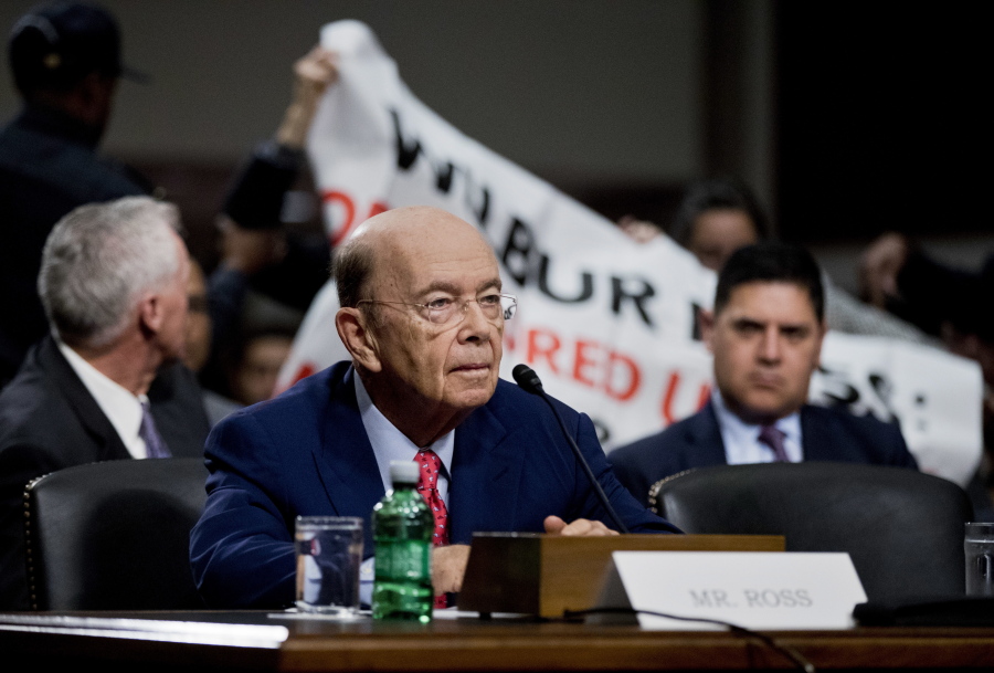 Protestors unfurl a banner on Capitol Hill in Washington on Wednesday during the Senate Commerce Committee&#039;s confirmation hearing for Commerce Secretary-designate Wilbur Ross, foreground.