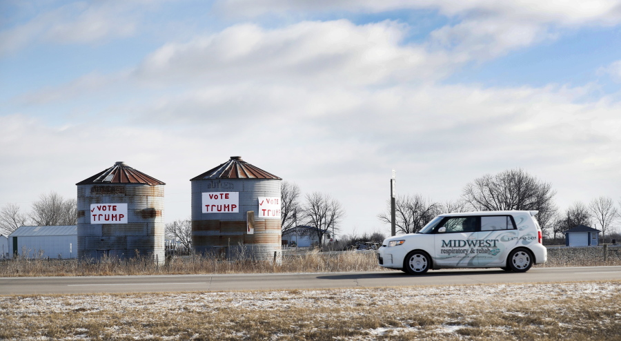 A car passes grain storage bins on a rural highway Friday in Ottumwa, Iowa. Far from the cacophony enveloping Washington in President Donald Trump&#039;s first week in office, the Iowa voters who helped him capture the state and the presidency last November give the president high marks for reversing eight years of Democrat Barack Obama&#039;s policies. But they shake their heads at his widely debunked claims about the crowd size for his inauguration and voter fraud costing him the popular vote.