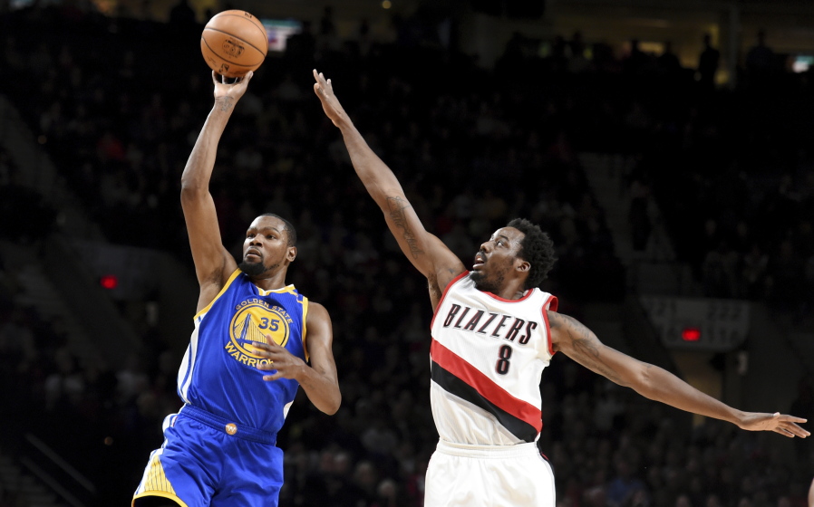 Golden State forward Kevin Durant scores two of his 33 points as Portland forward Al-Farouq Aminu defends during the first half Sunday in Portland.