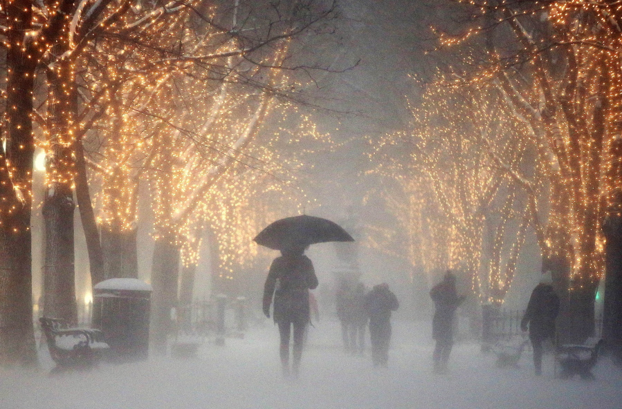 People walk through the Commonwealth Avenue Mall during a winter storm in Boston, Saturday, Jan. 7.
