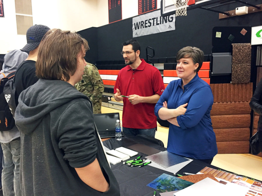 Students talk Thursday with Steelscape representatives Shelby Courtney, right, senior architectural coordinator, and Marshall Hood, area manager. The steel-coating plant at the Port of Kalama employs about 250 to 300 people.