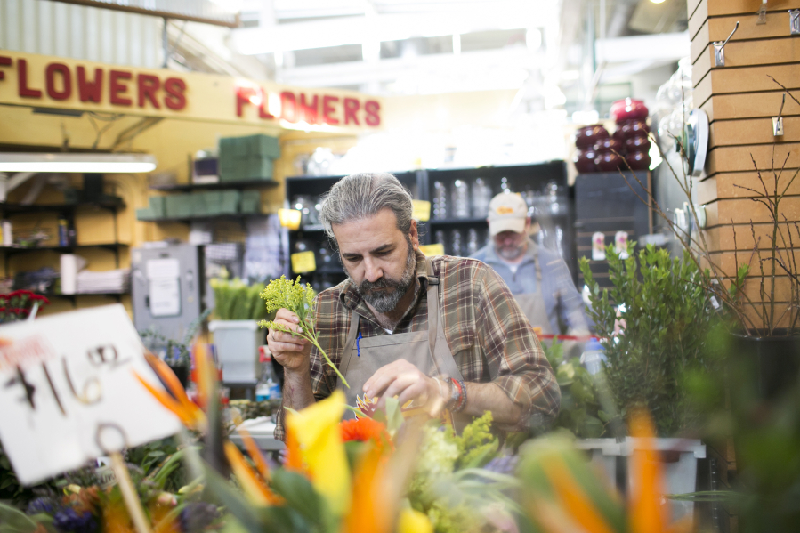Bob Mangia arranges flowers at the North Market, which has more than two dozen merchants.