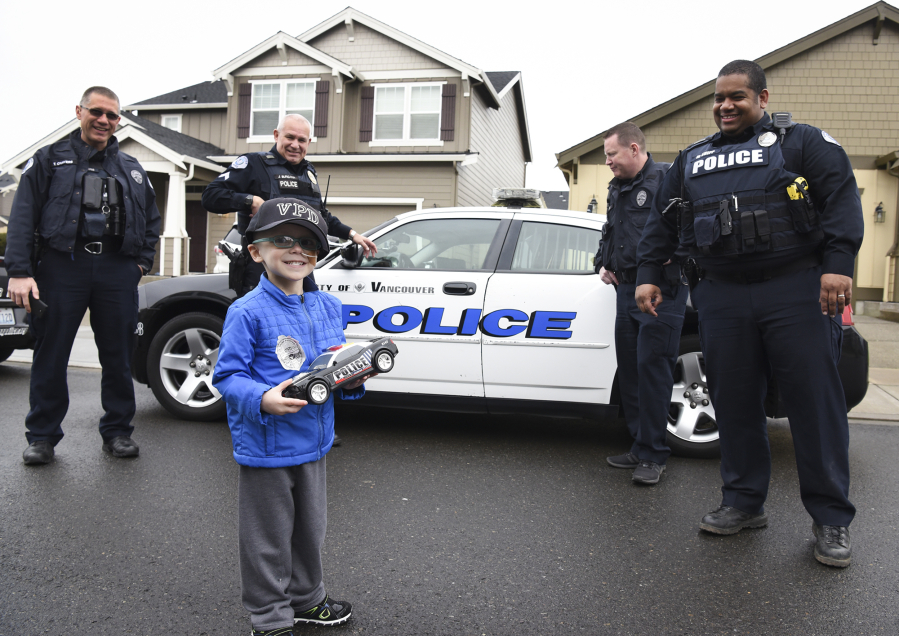 Nick Zadak, 4, smiles back at his mom before getting into a police car for a ride-along with Vancouver Neighborhood Police Officers, Tyler Chavers, from left, James Burgara, Erik Jennings and Mac Shipp at Zadak&#039;s home in Vancouver on Jan. 25. Nick died Thursday after battling hepatoblastoma, a pediatric liver cancer.