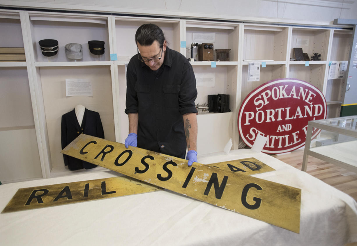 Vancouver resident Todd Clark helps arrange historical signs for an upcoming exhibit at the Clark County Historical Museum, which reopens Saturday.