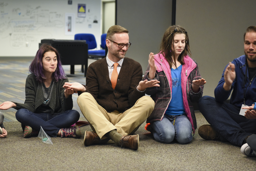 Principal Aaron Smith, center, plays the game &quot;Down by the Banks&quot; with seventh-graders May Williamson-Shilling, left, and Regan VanCleave, before class at the Camas Project-Based Learning Middle School.