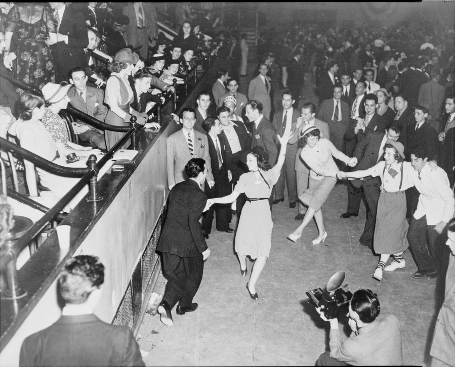 Couples jitterbug on a dance floor in 1938.