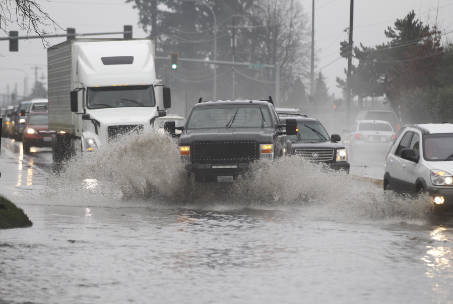 Drivers navigate standing water early this month on state Highway 503 near Northeast 87th Street in the Orchards area.