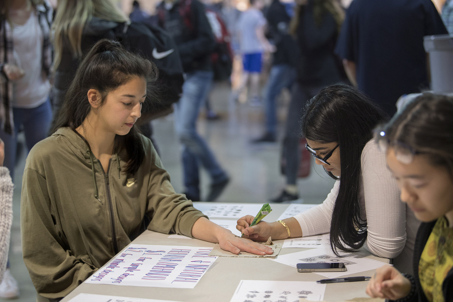 Freshman Odessa Thompson, 15, gets a henna tattoo from senior Hana Rabbani, 17, the vice-president of the Muslim Student Association, during Acceptance Week at Camas High School, in which four student organizations teamed up to create a week of educational events.