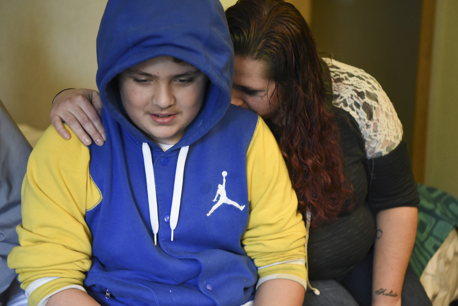 Ashly Oliver-Edwards, right, hugs her son, Mazzeo Sanchez, 12, after he recounted coming face-to-face with a man who entered their Vancouver apartment last week and armed himself with a knife. The man was later shot and killed by police. Oliver-Edwards, her four children and roommate Roger Duffey were displaced by the ordeal and are staying at a Vancouver hotel.