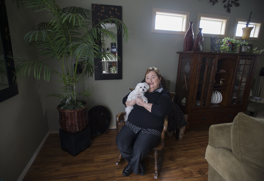Sherrie Hendricks, 71, who had the Watchman device implanted in September, is pictured with her dog, Mini, 2, Tuesday at her Vancouver home. The device helps to reduce the risk of stroke caused by blood clots without blood-thinning drugs.