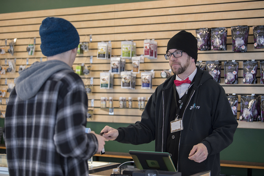 Budtender Jeff Sellers assists a customer with a purchase at The Herbery. Jim Mullen, the store&#039;s owner, said it hopes to win customers&#039; loyalty with service as the price of marijuana flowers tumbles.