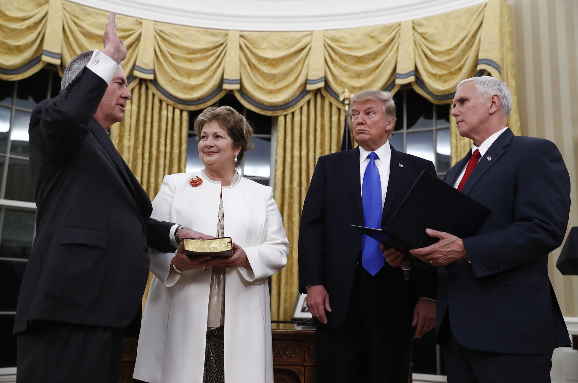 President Donald Trump watches as Vice President Mike Pence swears in Rex Tillerson as Secretary of State in the Oval Office of the White House in Washington, Wednesday, Feb. 1, 2017. Holding the Bible is Tillerson's wife Renda St. Clair.