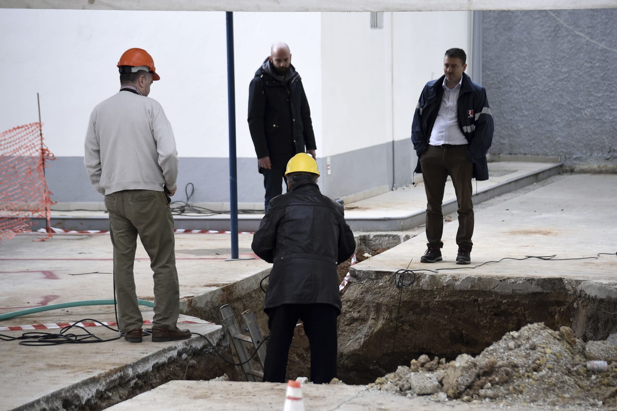 Experts check the location where an unexploded World War II bomb was found 5 meters (over 16 feet) deep, at a gas station in the northern Greek city of Thessaloniki, on Thursday, Feb. 9, 2016. Authorities in Greece's second-largest city on Sunday are planning to evacuate up to 60,000 residents from their homes so experts can safely dispose of the unexploded World War II bomb.